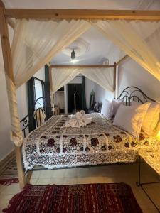 1 dormitorio con 1 cama grande con dosel en Riad Ago, en Marrakech