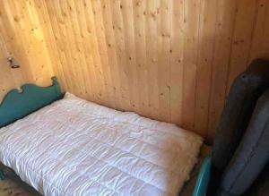 uma pequena cama num canto de um quarto em Hytte på idyllisk seter em Fosset