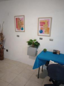 a room with a blue table and two pictures on the wall at El Yunque White House in Rio Grande