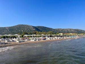 - une plage avec des chaises longues, des parasols et l'eau dans l'établissement Holiday Oasis with private patio and Hammam-style bath in Chora-Pithagoreo, Samos Island, à Chóra
