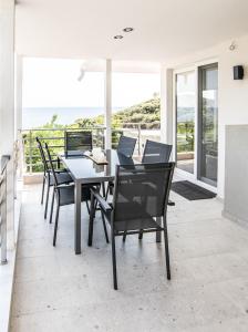 a dining room with a table and chairs and the ocean at Villa Mare in Mákri