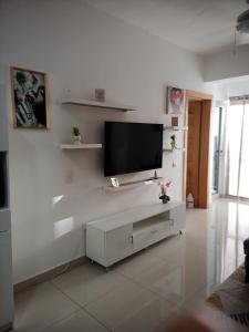 uma sala de estar branca com uma televisão de ecrã plano na parede em Simply the most comfortable place next to Boca Chica beach em Boca Chica