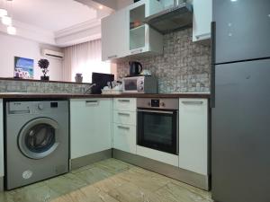 a kitchen with a washing machine and a washer at Lido Jinen Hammamet in Hammamet