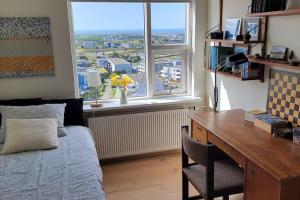a bedroom with a desk and a bed and a window at Pent house dublex with amazing city and Ocean views for 4 rooms 6 people in Reykjavík