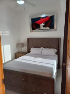 1 dormitorio con 1 cama y una pintura en la pared en Simply the most comfortable place next to Boca Chica beach, en Boca Chica