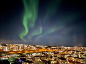 an image of a city with the aurora in the sky at Pent house dublex with amazing city and Ocean views for 4 rooms 6 people in Reykjavík