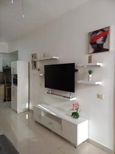 a living room with a tv on a white wall at Simply the most comfortable place next to Boca Chica beach in Boca Chica