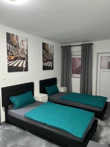 1 Schlafzimmer mit 2 Betten und blauen Kissen in der Unterkunft Pension Gergert Gundelsheim in Gundelsheim