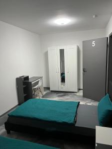 een slaapkamer met een bed, een bureau en een tafel bij Pension Gergert Gundelsheim in Gundelsheim