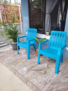 duas cadeiras azuis sentadas ao lado de uma casa em Casa en Playa Tambor - A 5 minutos de la playa em Tambor