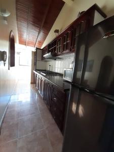 a kitchen with a black refrigerator and wooden cabinets at Apartamentos en Mérida Mejor precio garantizado in Mérida