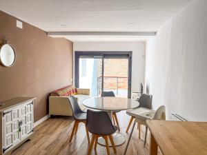 cocina y comedor con mesa y sillas en Casa Yama - Renovated House in the Center of Berga, en Berga