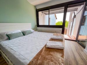 Cama grande en habitación con ventana grande en Casa Yama - Renovated House in the Center of Berga, en Berga