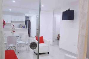 a white living room with a table and chairs at Moderno y nuevo departamento “Casa Blanca” in Trujillo