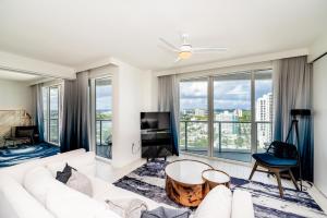a living room with a white couch and large windows at Beachfront Luxury 2BR 2BA, Sleeps 6, Resort Access - Horizon by HomeStakes in Fort Lauderdale