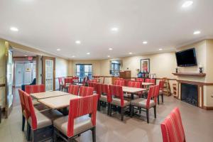 a restaurant with tables and chairs and a fireplace at Comfort Inn & Suites Mobile near Eastern Shore Centre in Spanish Fort