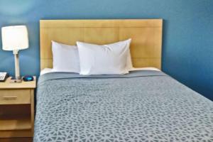 - un lit avec des oreillers blancs et un mur bleu dans l'établissement Suburban Studios Stuart near Federal Hwy 1, à Stuart