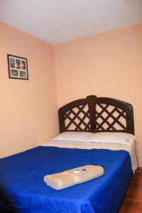 Ce lit se trouve dans un dortoir doté d'une couverture bleue. dans l'établissement Departamento Chiclayo Perú, à Chiclayo