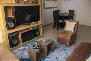 a living room with a large television and a table at Departamento Chiclayo Perú in Chiclayo