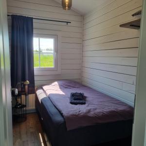 a bed in a room with a window at Cosy cottage in the countryside in Þingeyjarsveit