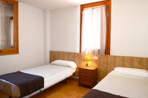 a small room with two beds and a window at La Coma in Taull