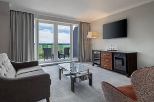 a living room with a television and a couch and chairs at Delta Hotels by Marriott York in York