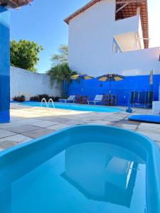 uma piscina em frente a uma casa com uma parede azul em Pousada Capitolio 02 Canoa Quebrada em Canoa Quebrada