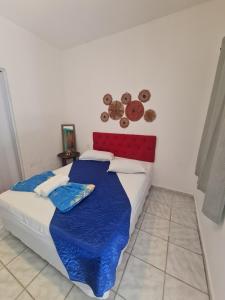 a bedroom with a bed with a blue blanket and plates on the wall at Capitolio Canoa Quebrada in Canoa Quebrada