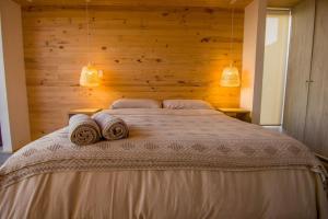 een slaapkamer met een bed met twee handdoeken erop bij Lafk Lodge in Pichilemu