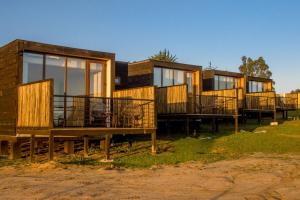 une rangée de maisons modulaires assises sur l'herbe dans l'établissement Lafk Lodge, à Pichilemu