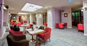 un restaurante con mesas y sillas rojas en una habitación en Poiana Brasov Alpin Resort Hotel Aparthotel 2204, private property, en Poiana Brasov