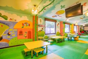 Poiana Brasov Alpin Resort Hotel Aparthotel 2204, private property في بويانا براسوف: غرفة ألعاب للأطفال مع طاولات وجدار جداري