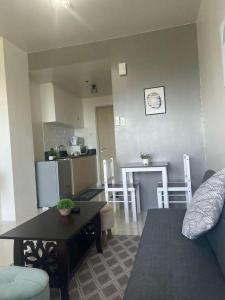 a living room and kitchen with a couch and a table at SMDC Wind residences in Tagaytay