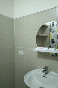 La salle de bains est pourvue d'un lavabo et d'un miroir. dans l'établissement SMDC Wind residences, à Tagaytay