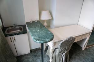 Habitación con escritorio con silla y lavabo. en Royal City Hotel, en Kiev