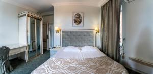 ein Schlafzimmer mit einem großen Bett und einem Spiegel in der Unterkunft Royal City Hotel in Kiew
