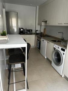 eine Küche mit einem Tisch und einer Waschmaschine in der Unterkunft Brilliant sea apartment in Villajoyosa