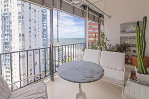 Habitación con mesa, sillas y balcón con vistas al océano. en Oceana Suites Lafayette, en Punta del Este