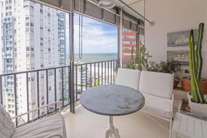 Habitación con mesa, sillas y balcón con vistas al océano. en Oceana Suites en Lafayette, vista al mar, en Punta del Este