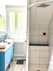 łazienka z 2 umywalkami i prysznicem w obiekcie Logement entier proche Disneyland w mieście Montry