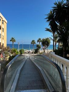 einen Fußweg zum Strand mit Palmen und dem Meer in der Unterkunft Brilliant sea apartment in Villajoyosa