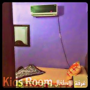 Zimmer mit einer lila Wand und einem TV an der Wand in der Unterkunft Air-conditioned apartment - شقة مكيفه للايجار ف ميامي in Alexandria