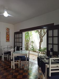 a dining room with a table and chairs and a window at Pousada Estrela do Mar in Salvador
