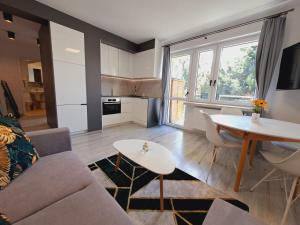 a living room with a couch and a table at Limanowa Sunriser Apartment in Limanowa