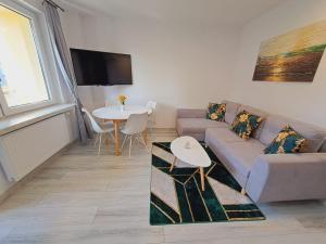 a living room with a couch and a table at Limanowa Sunriser Apartment in Limanowa
