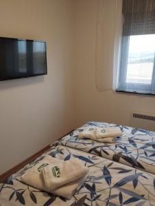 Un dormitorio con una cama con dos toallas encima. en Green Forest Lux Apartman, en Zlatibor