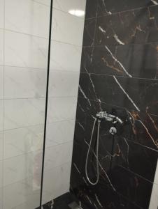 Un baño con una pared de mármol blanco y negro. en Green Forest Lux Apartman, en Zlatibor 13 fotos más