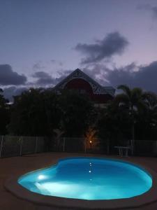 a large blue swimming pool in front of a building at Grand appartement duplex in Baie-Mahault