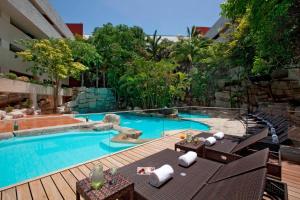 a swimming pool with a deck and chairs next to a building at Marriott Tuxtla Gutierrez Hotel in Tuxtla Guti&eacute;rrez