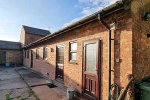 a brick building with a door on the side of it at Hillfields Farm Barn - A Rural Equestrian Escape in Coventry